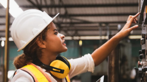 A woman in construction attire working in an industrial setting