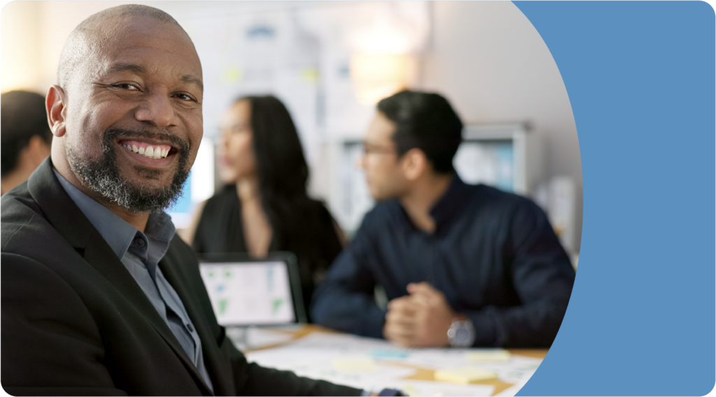 Man smiling in a boardroom with his colleagues