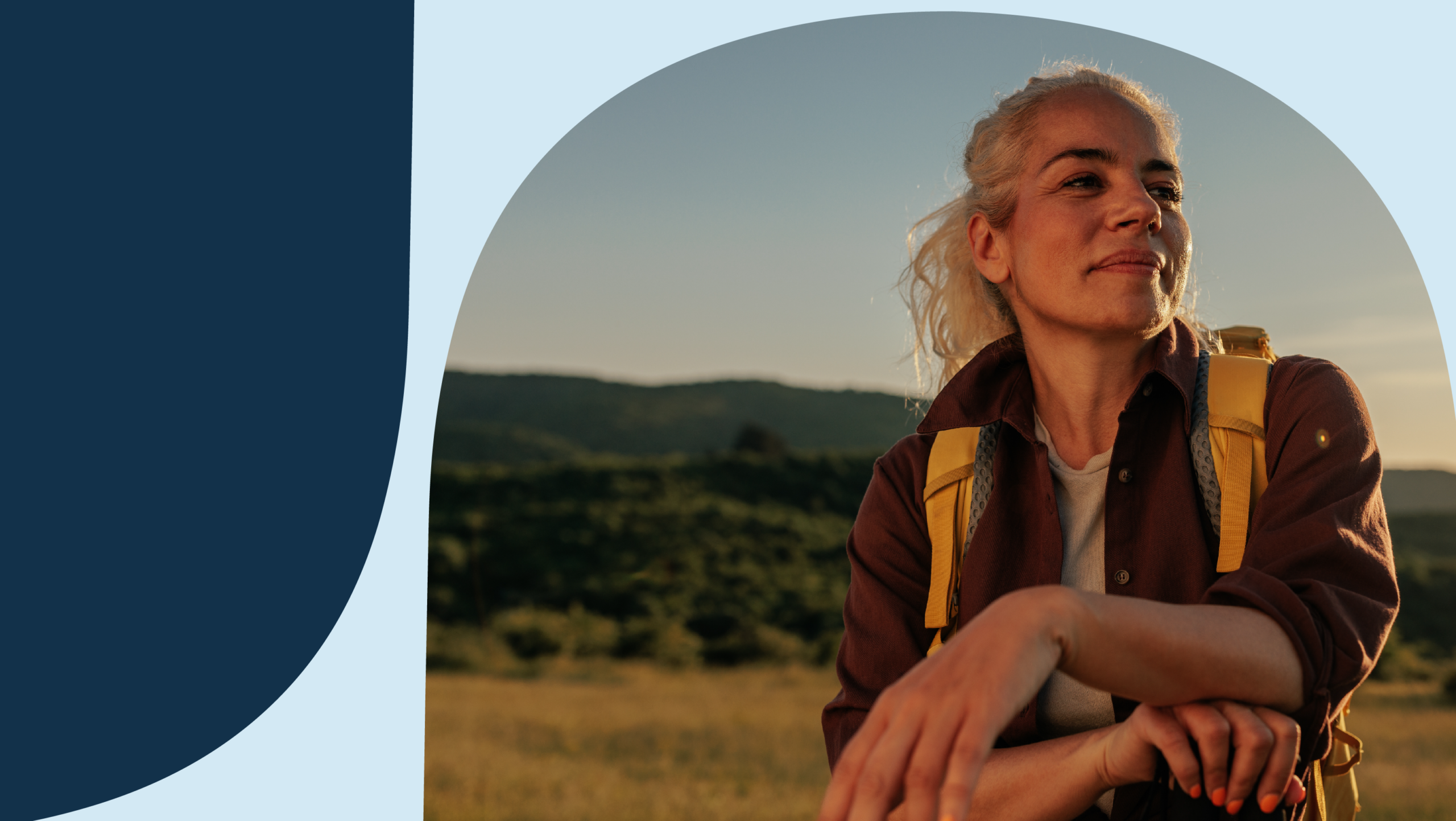 Woman hiking with a yellow backpack with green hills behind